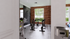 Modern fitness room with sleek spin bikes and motivational brick wall, overlooking lush greenery through large windows.