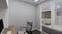 Modern office space with sleek desk, computer setup, and comfortable chairs, adjacent to a stylish living room with a cozy beige sofa and elegant decor.