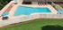 Inviting outdoor pool area with vibrant loungers and shaded umbrellas, perfect for relaxation and sunbathing.