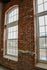 Charming loft apartment with exposed brick walls and large arched windows, offering a blend of historic character and modern style.