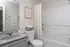 Elegant bathroom with a sleek granite countertop, modern fixtures, and a cozy shower area, complemented by neutral tones and stylish decor.