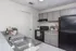 Modern kitchen with sleek gray cabinets, black appliances, and a dual stainless steel sink, creating a stylish and functional cooking space.
