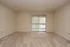 Bright and spacious room featuring soft carpeting, large window with vertical blinds, perfect for an inviting living area or bedroom.