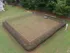 Inviting fenced dog park offering lush greenery, a spacious play area, and relaxing seating for pet owners.