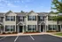 Charming townhouse exterior with beautiful landscaping and ample parking in a peaceful neighborhood.