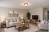 Chic and cozy living room featuring a plush beige sofa, elegant armchair, and stylish wooden furniture with decorative accents.