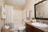 Chic bathroom featuring elegant lighting, polished countertop with sink, plush towels, and a stylish shower area.