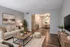 Inviting living room with modern decor, cozy beige sofas, wooden coffee table, and lush green accents leading to a stylish dining area.