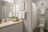 Bright and inviting bathroom featuring a large mirror, modern sink, and elegant decor with fresh towels and artwork.