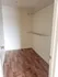 Spacious walk-in closet with elegant hardwood flooring and modern open shelving, perfect for stylish storage.