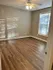 Inviting bedroom with elegant wood flooring, large window, and ceiling fan for optimal comfort and natural light.