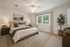 Inviting bedroom featuring a king-sized bed with elegant linens, soft lighting, and a scenic view from a large window, perfect for relaxation.