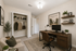 Elegant home office setup featuring a stylish wooden desk, comfortable leather chair, and minimalist decor with built-in closet and cozy seating area.