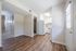 Charming apartment interior with sleek wooden floors, bright walls, and a compact kitchen area.