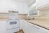 Bright and modern kitchen with sleek white cabinets, spacious countertops, and ample natural light.