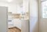 Bright and inviting kitchen with modern white cabinetry, sleek countertops, and large window for natural light.