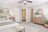 Inviting bedroom with elegant décor, neutral tones, and ensuite bathroom, complete with plush carpet and stylish ceiling fan.