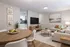 Inviting open-concept apartment living room with a cozy beige sofa, modern wooden dining set, and sleek kitchen design.