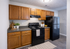 Charming kitchen with rich wooden cabinets, modern appliances, and sleek countertops, perfect for culinary creativity.
