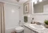 Elegant bathroom with a modern granite countertop, white tiles, and vibrant plant decor for a refreshing atmosphere.