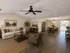 Inviting open-concept living and dining area with elegant decor, featuring a cozy sofa, stylish chairs, and a spacious dining table, complemented by warm lighting and hardwood flooring.