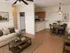 Inviting open-plan living space with cozy seating, warm wood flooring, and a charming dining area adjacent to a modern kitchen.