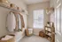 Elegant walk-in closet with natural light, featuring neatly organized clothes, woven baskets, and stylish shelving.