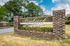 Welcoming entrance sign of Pembrook Apartments surrounded by lush greenery, showcasing a serene living environment.