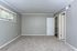 Spacious bedroom with plush carpeting, neutral-colored walls, and ample natural light from a wide window.
