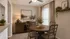 Charming dining room with a rustic wooden table, elegant decor, and natural light pouring through a large window, offering a cozy and inviting atmosphere.