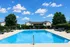 Inviting residential outdoor pool area with modern lounge chairs and lush greenery, perfect for relaxation and leisure.