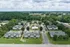 Charming apartment community with lush green surroundings and ample parking, featuring cozy buildings and a spacious central courtyard.