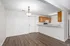 Charming open kitchen with sleek hardwood floors and elegant cabinetry, perfect for modern living.