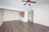 Bright and inviting living space with hardwood floors, modern ceiling fan, and open-plan kitchen area.
