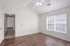 Bright and airy room with sleek wooden floors and a large window letting in natural light.