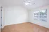 Bright, airy room with elegant hardwood floors and large sunlit windows, perfect for a cozy retreat.
