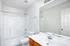 Bright, modern bathroom featuring a clean white shower, sleek vanity, and elegant lighting.