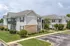 Charming apartment building with modern siding, well-maintained landscaping, and ample parking space.