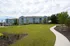 Charming apartment complex with modern design surrounded by lush greenery and a paved walkway.