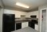 Modern kitchen with sleek black appliances, ample cabinet space, and cozy lighting.