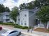 Charming apartment complex with lush greenery, private balconies, and a serene suburban setting.