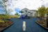 Inviting playground area surrounded by lush greenery, featuring vibrant blue slides and modern play structures, perfect for family-friendly living.