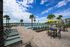 Inviting outdoor pool area with comfortable lounge chairs, sunny yellow umbrella, and stunning waterfront views, ideal for relaxation and leisure.