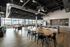 Modern open-concept common area with sleek kitchen, stylish seating, and floor-to-ceiling windows offering stunning city views.