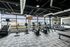Modern fitness center with state-of-the-art equipment, expansive windows, and urban skyline views.