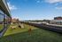 Vibrant rooftop dog park with stunning city views and a playful golden retriever enjoying a sunny day.