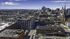 Breathtaking aerial view of a vibrant cityscape showcasing towering buildings, lively streets, and a picturesque skyline under a clear blue sky.