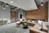 Modern industrial living space with exposed brick walls and stylish lighting fixtures, featuring a spacious sectional couch and contemporary decor.