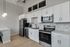 Modern kitchen with sleek white cabinets, stainless steel appliances, and elegant pendant lighting.