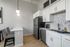 Modern kitchen with sleek white cabinetry, stainless steel appliances, and stylish pendant lighting, perfect for contemporary living.